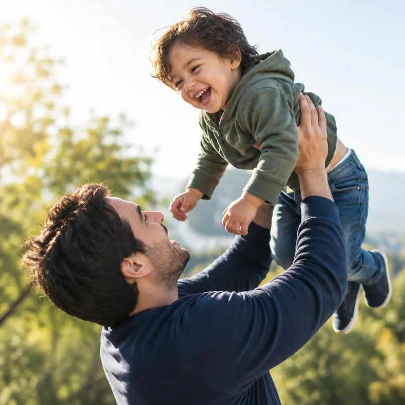 Father lifting a laughing child into the air outdoors
